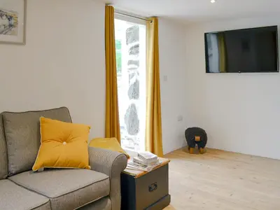 a living room with a couch and a window at Ysgoldy Salem in Mallwyd