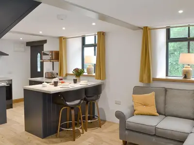 a kitchen and living room with a bar and a couch at Ysgoldy Salem in Mallwyd