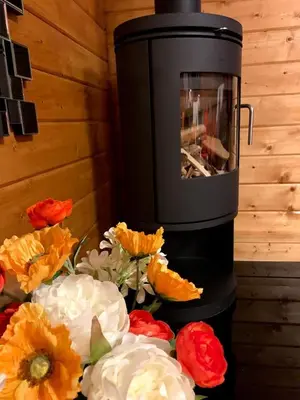 a stove with flowers in front of a wall at Long Wood Lodges in Knighton