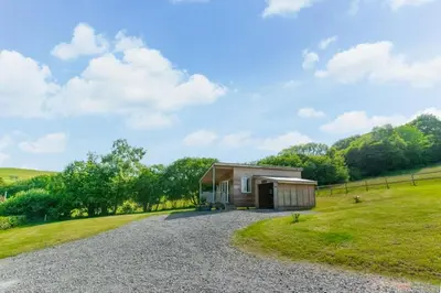a small cabin in a field with a gravel driveway at 1 Bed in Lower Chapel oc-waa396 in Lower Chapel