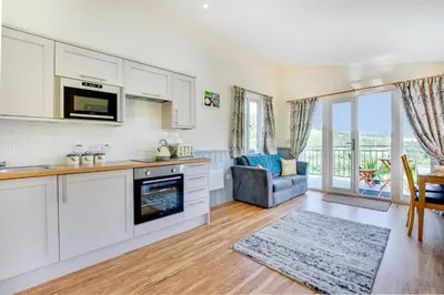 a kitchen with white cabinets and a living room at 1 Bed in Lower Chapel oc-waa396 in Lower Chapel