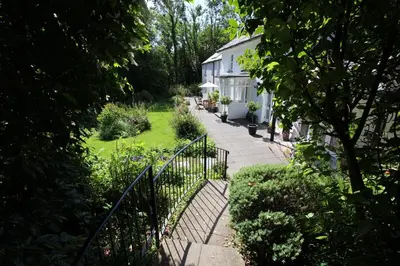 a garden with a fence and a white house at Rhydyfran House Aberaeron, Lampeter, West Wales, Ceredigion in Lampeter