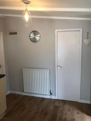 an empty room with a door and a clock on the wall at 49 Irfon Lodge in Builth Wells