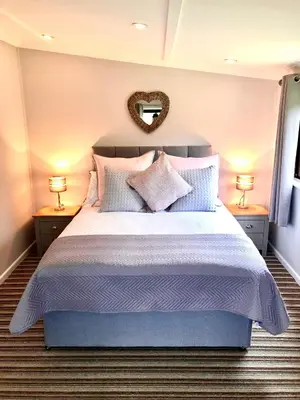 a bedroom with a large bed with pillows and a mirror at 49 Irfon Lodge in Builth Wells
