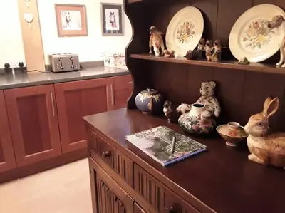 a kitchen with a wooden table with vases and plates at THE RETREAT in Hereford
