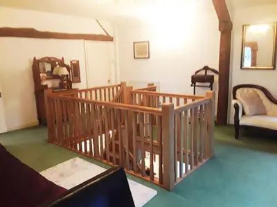 a living room with a wooden staircase and a couch at THE RETREAT in Hereford