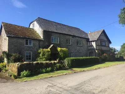 an old stone house on the side of a road at Lower House Farm B&B, Herefordshire in Hergest
