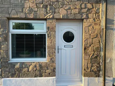 a stone building with a white door and a window at Westend Holiday Let 1 Brecon in Brecon