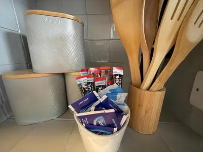 a container of utensils next to a trash can and wooden utensils at Westend Holiday Let 1 Brecon in Brecon