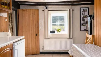 a kitchen with a door and a window and a table at Maes Glas in Mallwyd