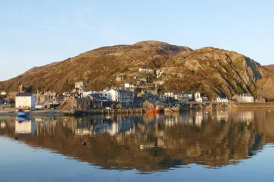 a small town on a hill next to a body of water at Bae Abermaw Hotel in Barmouth