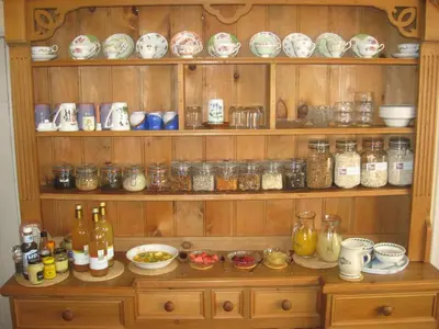 a wooden cabinet filled with lots of jars and dishes at Walford Court in Leintwardine