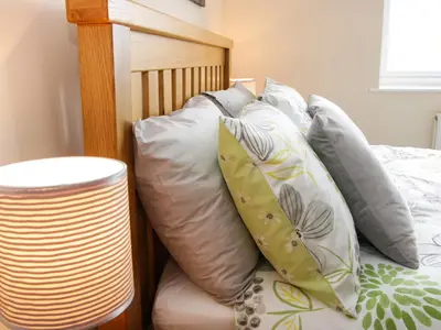 a bed with a bunch of pillows on it at Caesamson in Caersws