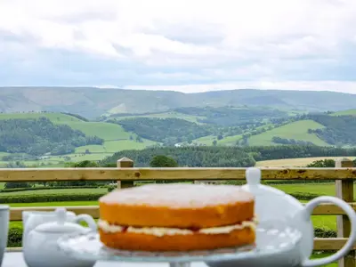 a cake on a plate on a table with a view at Caesamson in Caersws