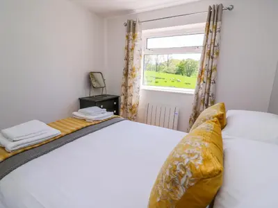 a bedroom with a bed and a window at Owl Cottage in Llandrindod Wells