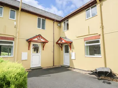 a yellow building with two white doors at Owl Cottage in Llandrindod Wells