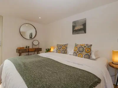 a bedroom with a large bed and a mirror at The Dutch Barn in Leominster