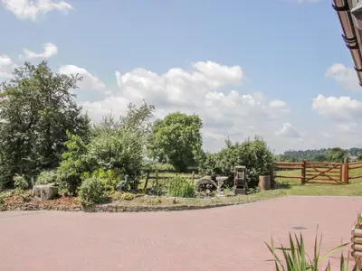 a garden with a fence and trees in a field at The Boundary Annex in Bishops Castle
