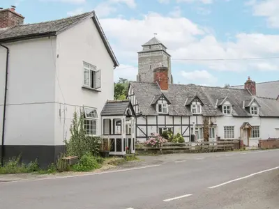 an old house on the side of the road at Manor Farm Lodges - Dragon Lodge in Newtown