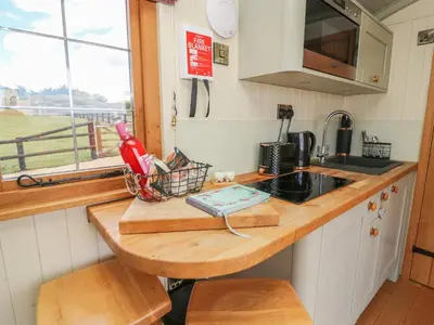 a kitchen with a counter with a sink and a window at Ivy's Way in Rhayader