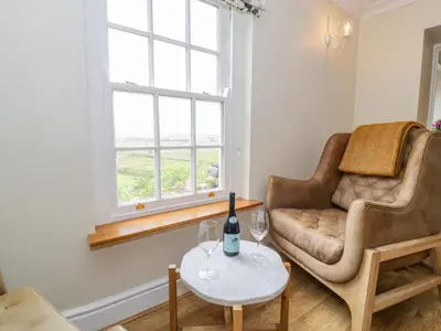a living room with a couch and a table with wine glasses at Llety Perygl in Harlech