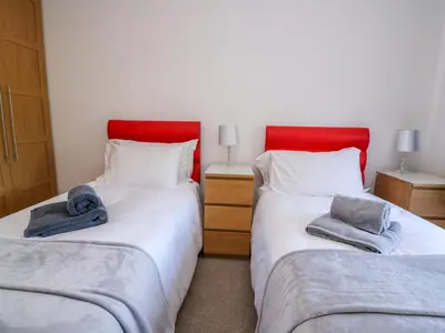 two beds with red headboards in a room at Ty'r Orsaf in Builth Wells