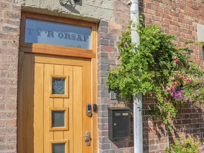 a wooden door on a brick building with a sign above it at Ty'r Orsaf in Builth Wells