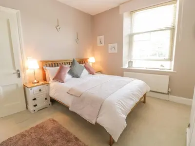 a bedroom with a large bed and a window at Angorfa in Llanbedr