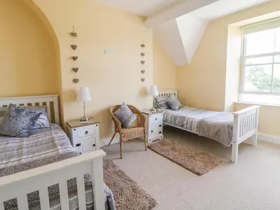 a bedroom with two beds and a window at Angorfa in Llanbedr