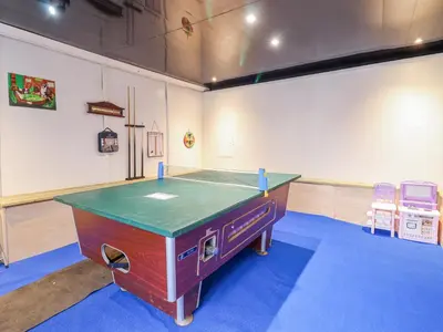 a ping pong table in a room with two chairs at Minydon in Fairbourne