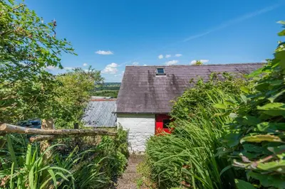 a barn with a red door in a field at 2 Bed in Llandeilo oc-waw313 in Talley