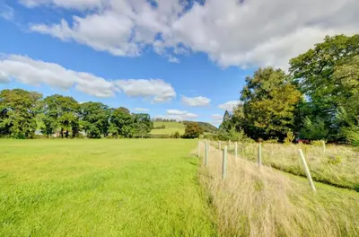 a fence in a field with trees in the background at 2 Bed in Crugybar oc-waw323 in Llansawel