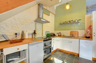 a kitchen with white cabinets and a stove top oven at 2 Bed in Crugybar oc-waw324 in Llansawel