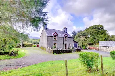 an old house with a fence in front of it at 3 Bed in Dolgellau oc-wah464 in Llanfachreth