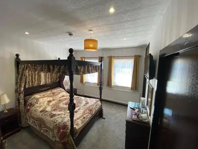 a bedroom with a canopy bed and a window at The Griffin Llyswen in Brecon