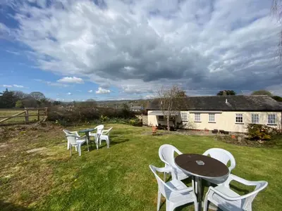a group of tables and white chairs on a yard at The Griffin Llyswen in Brecon