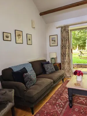 a living room with a couch and a window at Courtyard Cottage in Oswestry