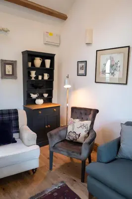 a living room with a couch and a chair and a table at Courtyard Cottage in Oswestry
