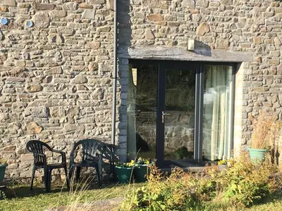 a stone house with two chairs and a window at Garden Room near Brecon in Brecon