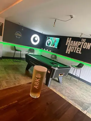 a pint of beer sitting next to a ping pong table at Hampton Hotel & restaurant in Llandrindod Wells
