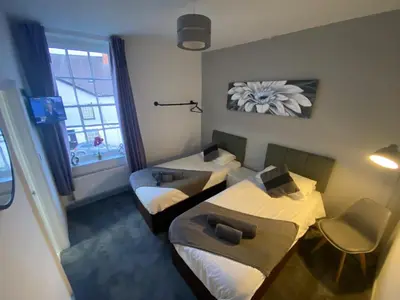 a small room with two beds and a window at The Swan Hotel in Kington