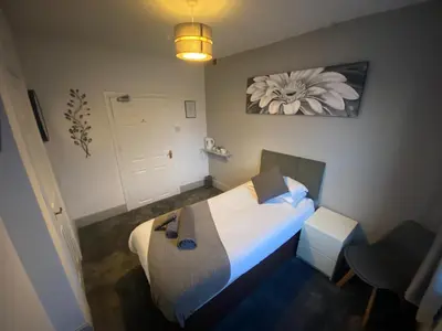 a small room with a bed and a lamp at The Swan Hotel in Kington