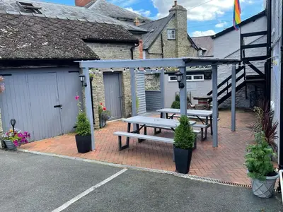 a picnic table on a brick patio next to a garage at The Swan Hotel in Kington