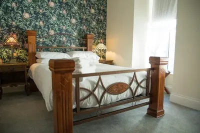 a bedroom with a bed with a floral wallpaper at The Royal in Barmouth