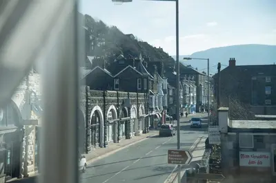 a city street with buildings and cars on the road at The Royal in Barmouth