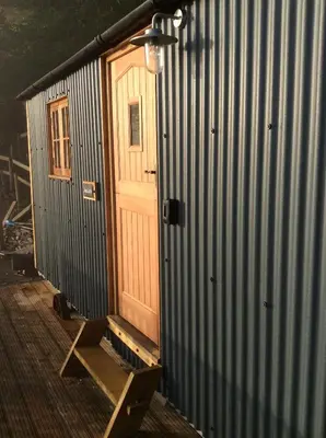 a wooden door on the side of a building at Llangollen Shepherds Huts in Llangollen