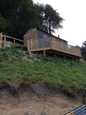 a house sitting on top of a hill at Llangollen Shepherds Huts in Llangollen
