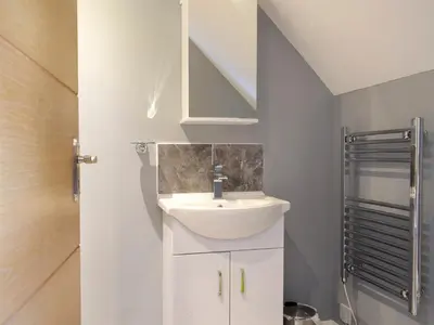 a bathroom with a sink and a staircase at Windhover in Glasbury