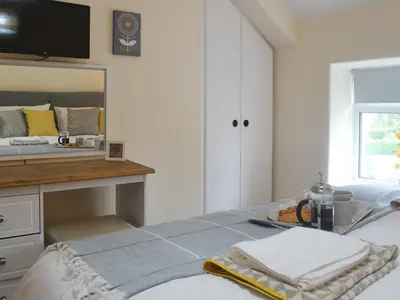 a bedroom with a bed with a sink and a mirror at Pen Parc in Bryn-crug