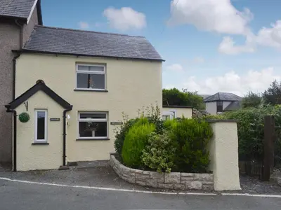 aige house with a window and a bush at Pen Parc in Bryn-crug